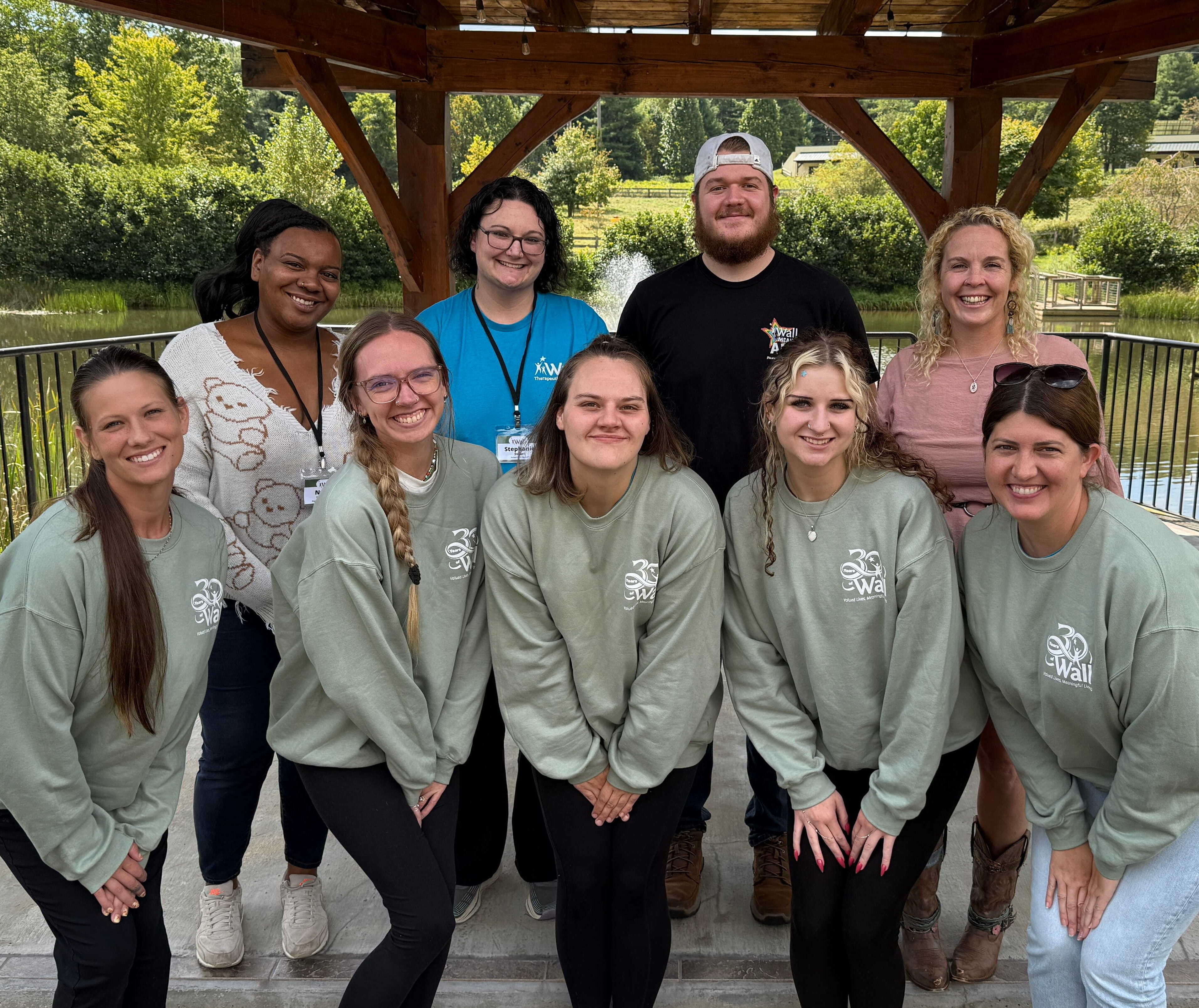 Wall therapeutic solutions staff posing in front of a lake at a conference