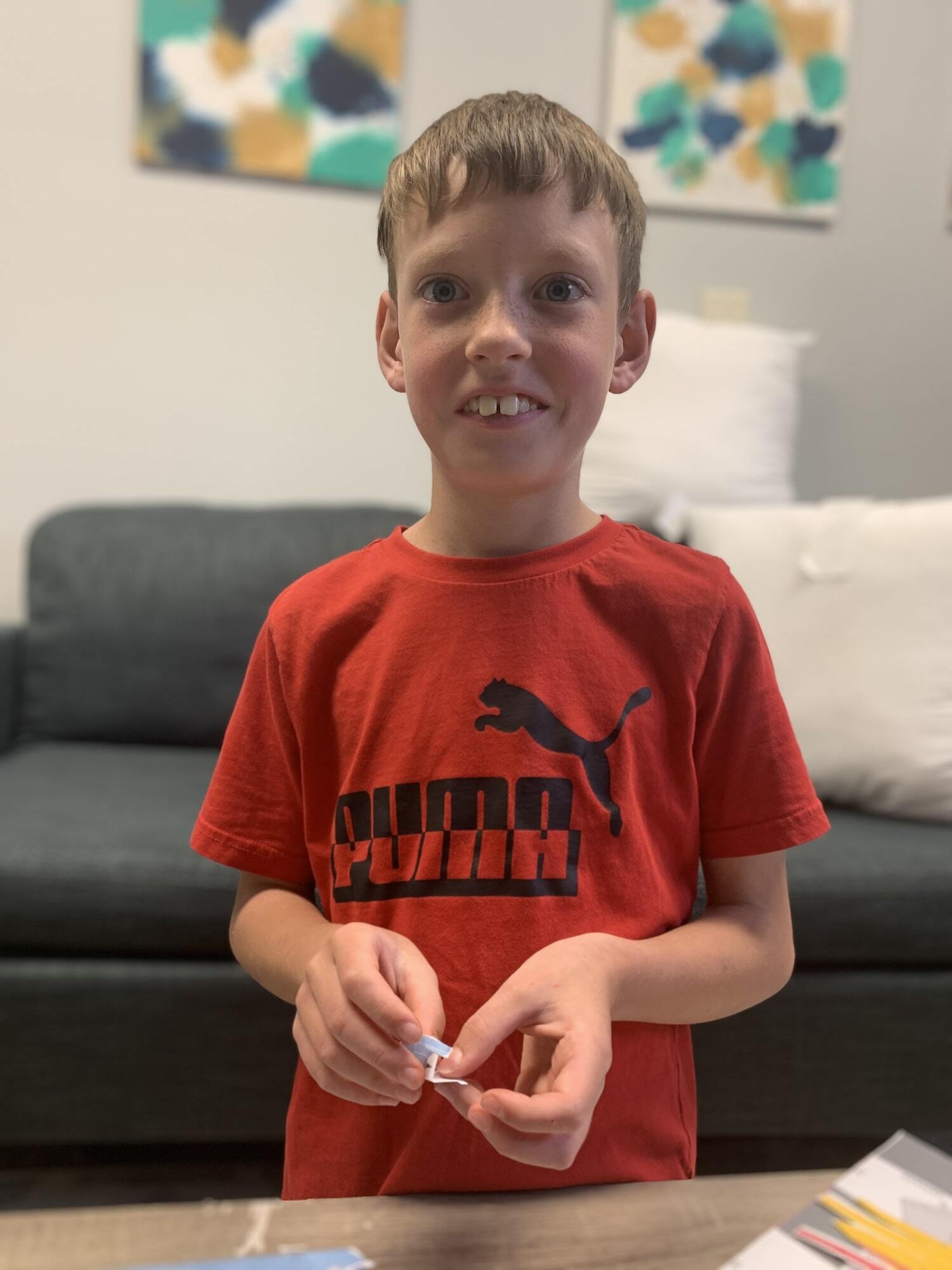 A young boy in a red shirt smiling at Wall Therapeutic Solutions