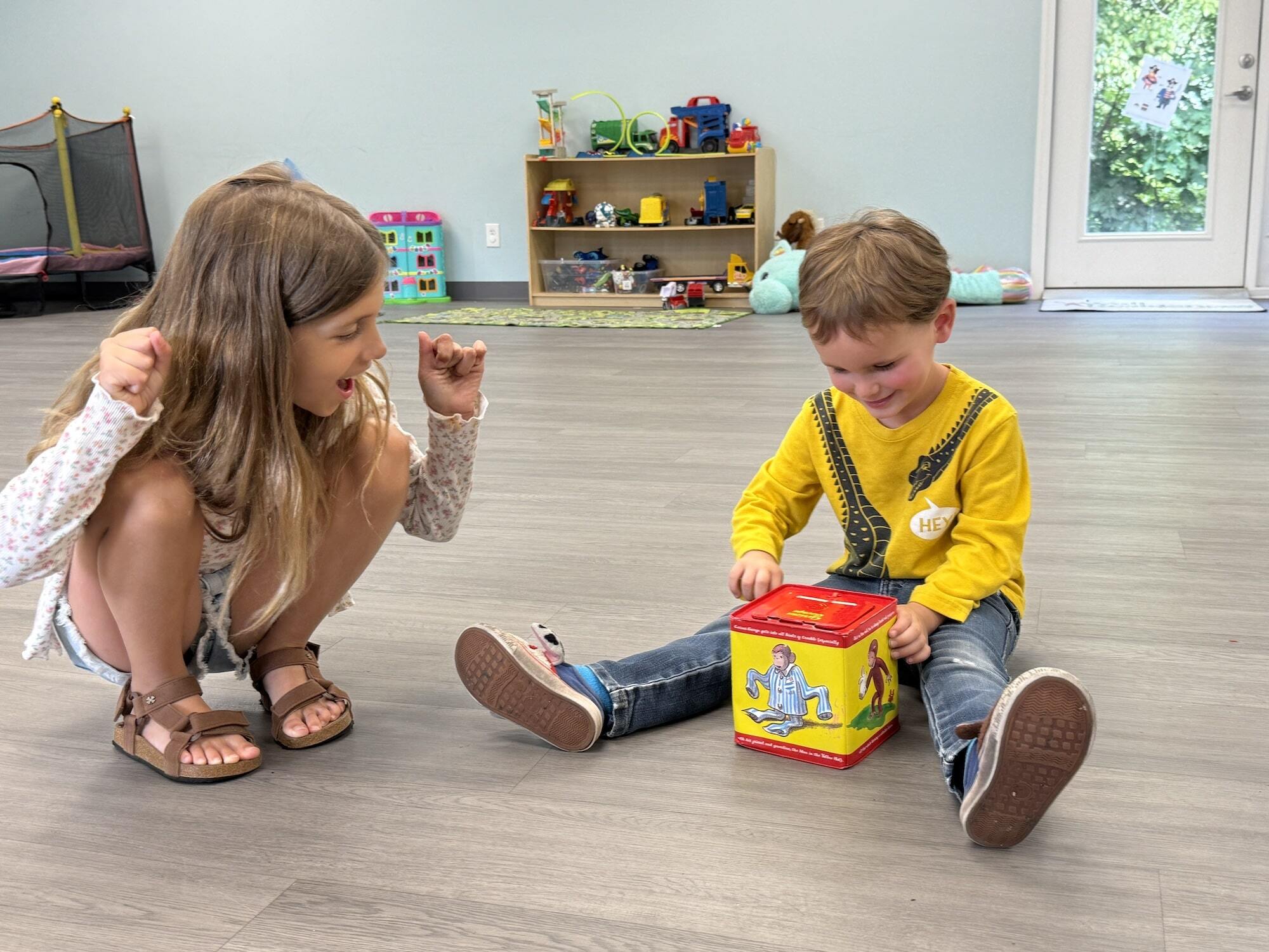 A young girl and boy interacting and playing with toys at the ABA center