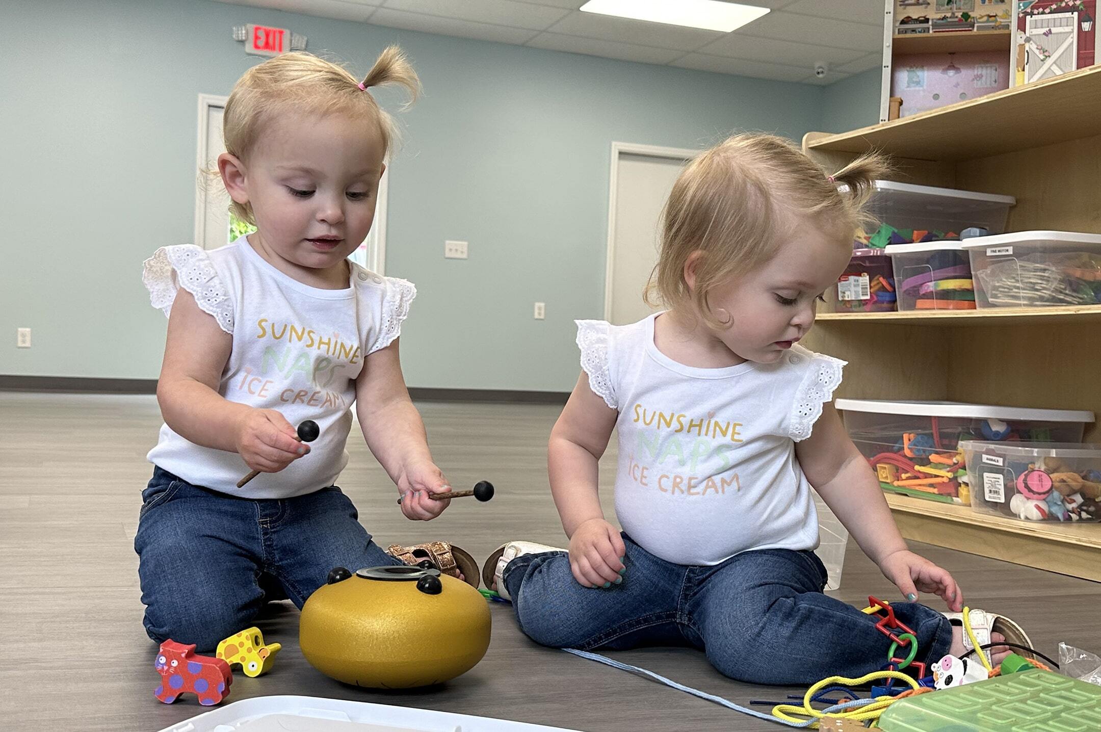 Twin girls play with musical toys at ABA Center